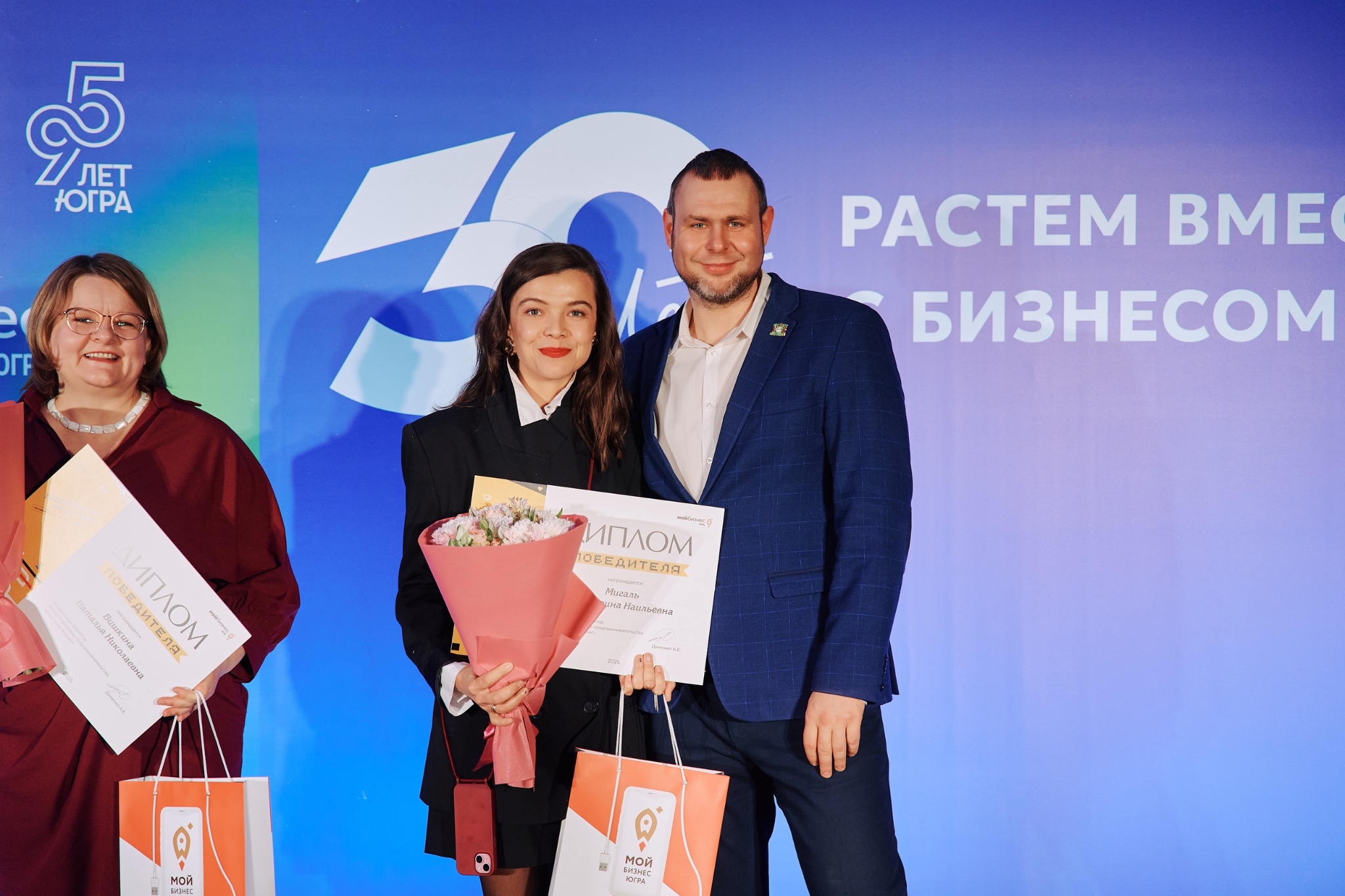Екатерина Мигаль с дипломом и мужчиной, вручающим награду