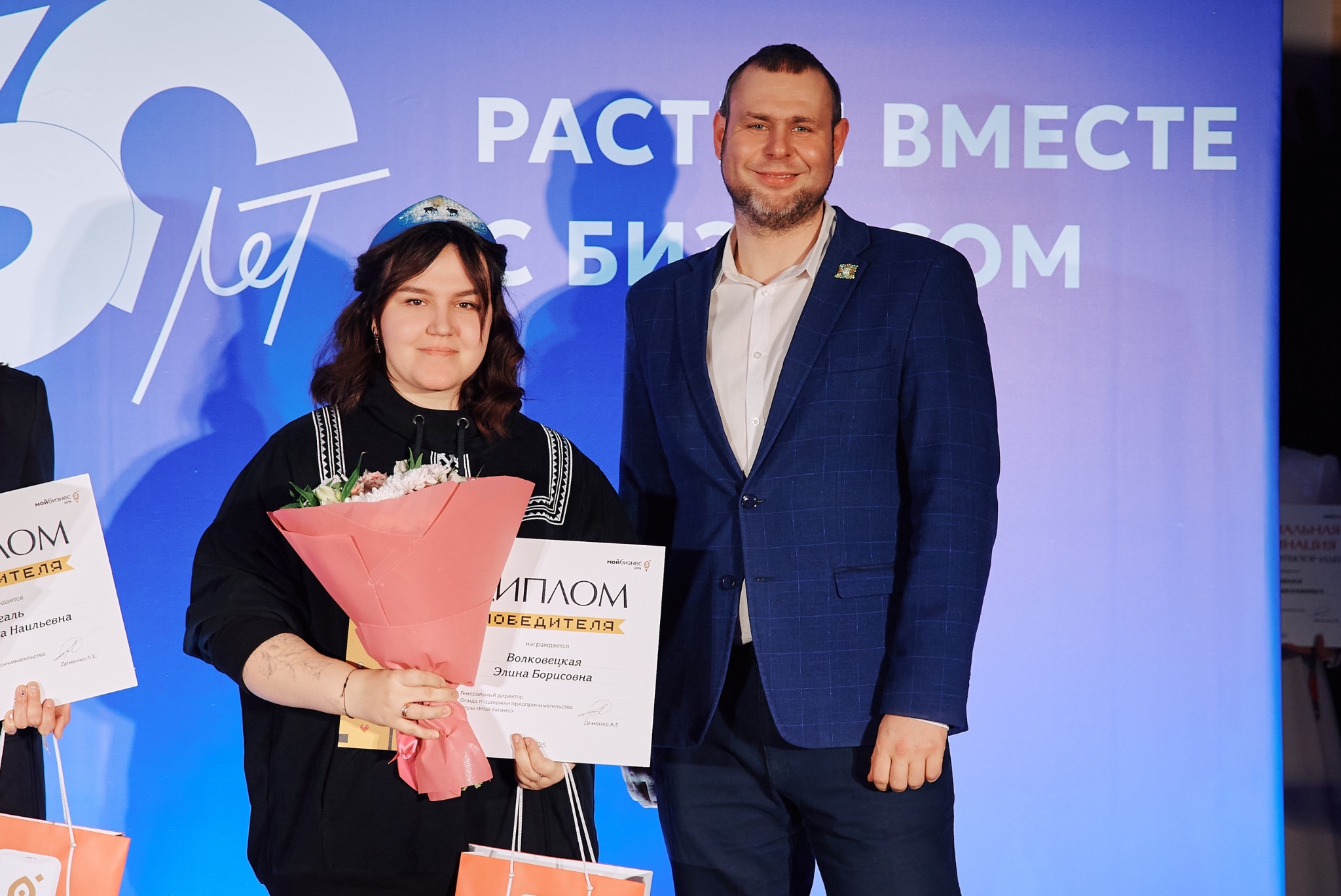 Элина Волковецкая с дипломом и мужчиной, вручающим награду